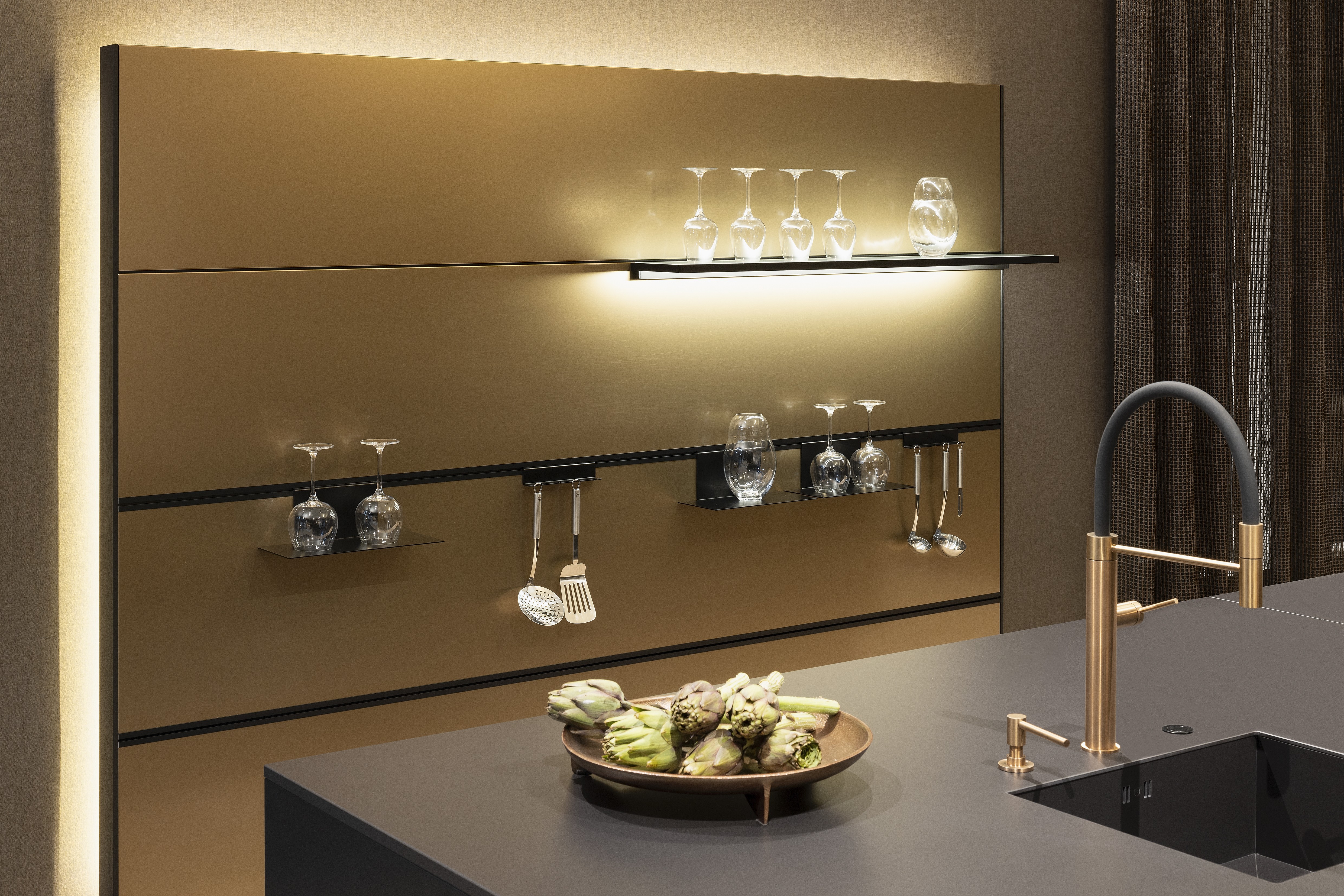 APL: Silk Negro Naturale (Keramik) 16 mm   Front: AV 6023-GL Eiche-schwarz Echtholzfurnier Rille AV 7070 Industriestahl Bronze, Metalliclack Korpus: 4059 Titan Griff: Kehlleiste 355 Schwarz matt Geräte: Miele Armatur: Gessi Features: Regalwandlösung mit beleuchtetem Wandboard, Oberfläche von Hand bearbeitet, Materialmix, Trendthema Bronze, Glasschublade mit Plexiglas in Schwarz getönt, Thekenlösung mittig, Wand aus Oberflächenmaterial in Bronze mit beleuchteten Funktionsleisten für Gläser, etc. 