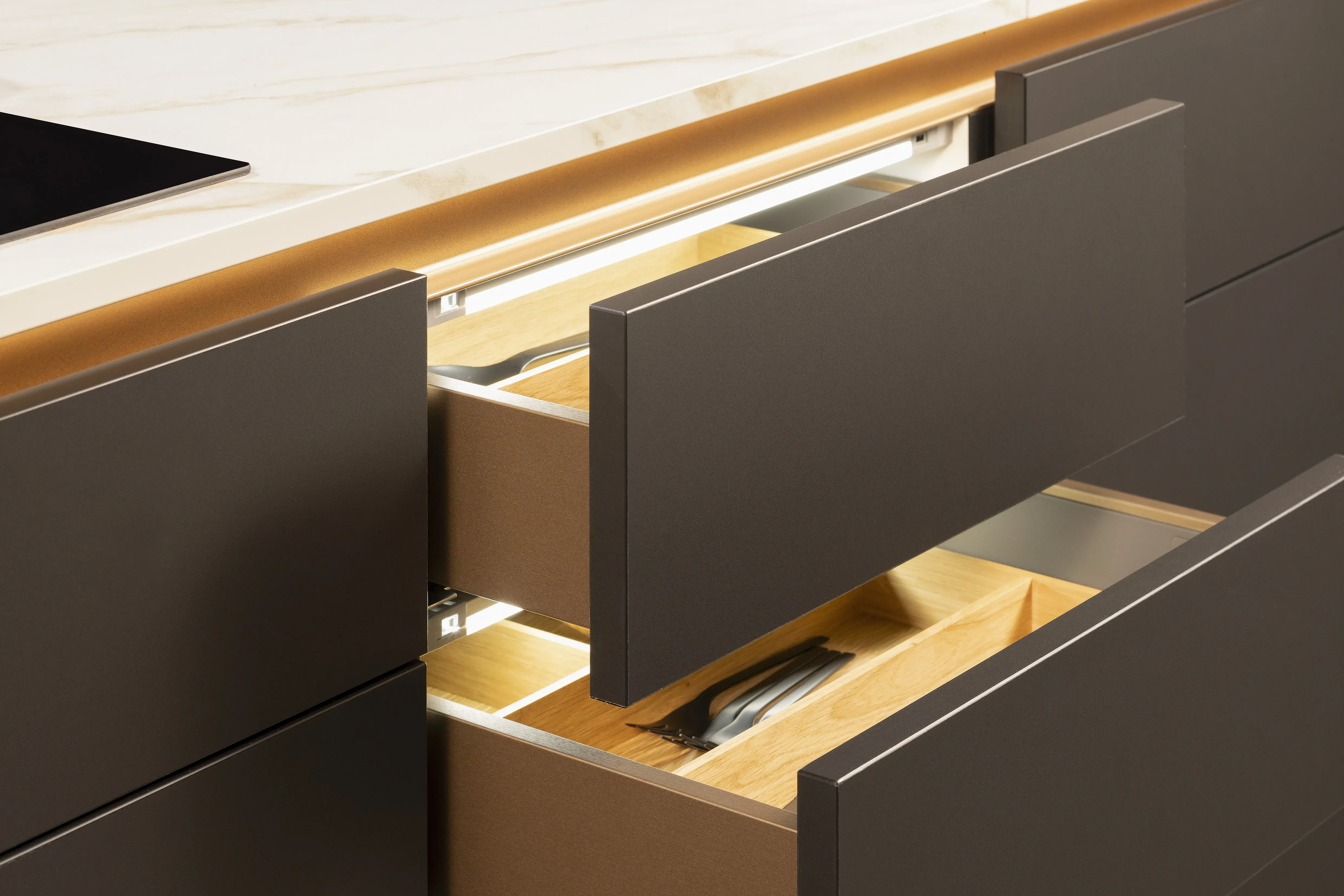 APL: 324 Marmor Carrara Bronze NB Korpus: 127 Schwarz Front: 496 Senso Lack Schwarz Premium matt Griff: Bronze Metallic (Line N) Geräte: Bosch Armatur: Gessi  Spüle: Rodi  Features: Neue Front in Trendfarbe Schwarz matt, Nischenelement mit Spielerückwand Farbe Bronze, beleuchtete Griffleiste, Push to open, neuer Schubkasten, Korpusfarbe schwarz, neues Nischendekor Bronze Glas, Trendfarbe Bronze (Eurocucina Milano), APL in Marmoroptik, Spülbecken und Armatur in Bronze, beleuchtete Regalleisten,Vorratsschrank